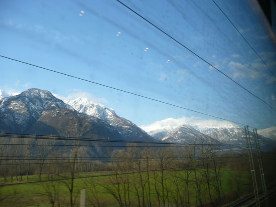 Vanuit de trein uitzicht op de besneeuwde bergtoppen...