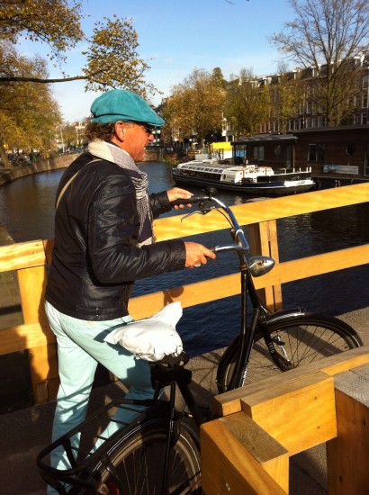 Op de fiets, door Amsterdam, het beste vervoermiddel, hier. Ik achterop de gammele fiets van Sandy...